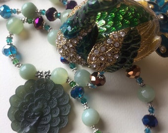 Superbe collier de jade célébrant la beauté de la queue attisée du paon.