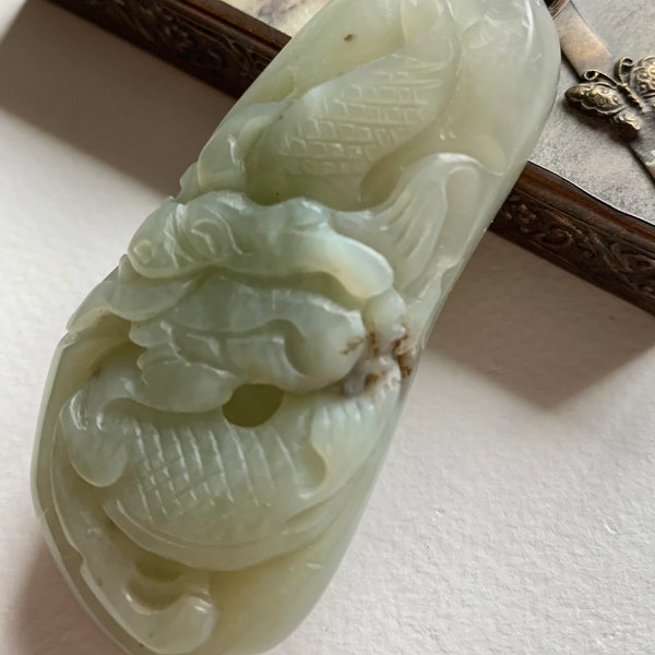 Deux poissons gravés sur un pendentif de jade