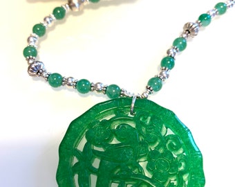 Delicate carving of a magpie and a plum blossom on a green jade pendant