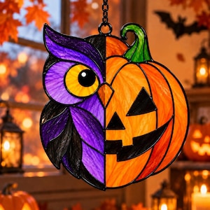 May include: A stained glass suncatcher featuring a split design with a purple and black owl on the left and an orange jack-o'-lantern pumpkin on the right. The piece is suspended by a black metal chain and features a bright yellow owl eye.