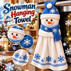 Peut inclure: Une serviette suspendue blanche avec une tête de bonhomme de neige en peluche portant un chapeau bleu, une écharpe bleue brodée de flocons blancs et une base en tissu blanc ornée de motifs de flocons bleus et d'une bordure.