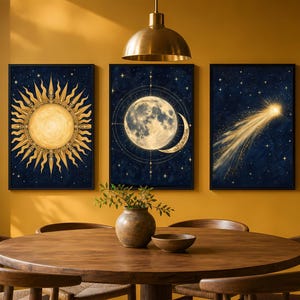Pode incluir: Um conjunto de três quadros de parede com temas celestiais sobre um fundo azul escuro. O quadro da esquerda exibe um sol dourado, o central mostra uma lua detalhada com linhas geométricas e o da direita retrata um cometa brilhante.