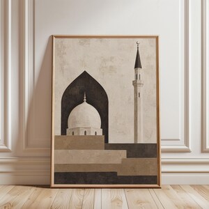 May include: A framed wall art print featuring a stylized illustration of a mosque with a white dome set within a dark arched entryway and a tall minaret topped with a crescent moon. The composition uses a neutral palette of beige, tan, and dark brown.