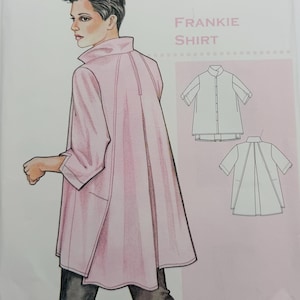 May include: A sewing pattern envelope for The Sewing Workshop Frankie Shirt. The cover features an illustration of a person wearing a light pink, loose-fitting shirt with a high collar and back pleat, alongside technical line drawings of the garment.