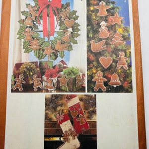 May include: Simplicity sewing pattern number 9648 for making gingerbread ornaments. The pattern includes instructions for making a wreath, ornaments for a Christmas tree, and a stocking. The pattern is for one size.