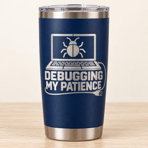 May include: A dark blue stainless steel tumbler with a clear lid. The front features a laser-engraved graphic of a laptop with a bug icon on the screen and the text "DEBUGGING MY PATIENCE" below it, with a cable extending from the text to a USB plug.