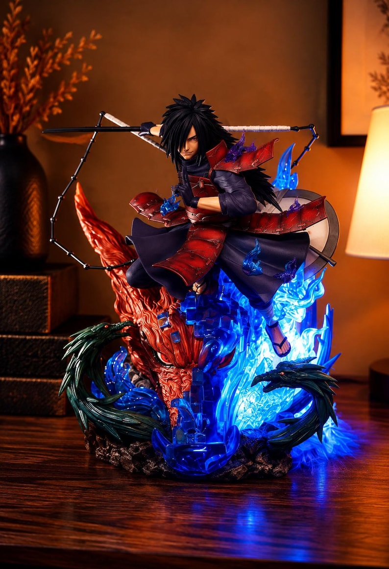 May include: A detailed anime character figurine featuring a dark-haired warrior in red and black samurai-style armor. The figure is posed dynamically amidst swirling translucent blue energy flames and a large, textured orange dragon head.