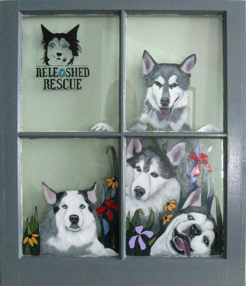 May include: A window with four panes, each featuring a painted image of a husky dog. The top left pane has the text "RELEASHED RESCUE".