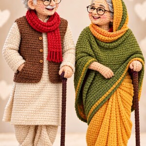 May include: Two crocheted dolls representing an elderly couple. The figure on the left wears a beige tunic, brown vest, red scarf, and brown sandals. The figure on the right wears a green and yellow sari with a matching head covering and glasses.