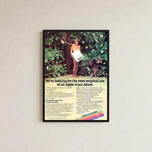 Peut inclure: Une affiche publicitaire vintage Apple Computer de 1980 dans un cadre noir. Elle montre une personne debout dans une jungle luxuriante tenant un ordinateur Apple II. Le texte indique, We're looking for the most original use of an Apple since Adam.