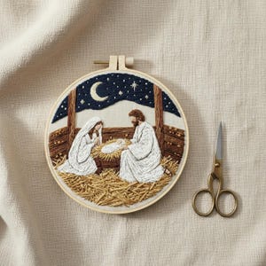 Könnte beinhalten: Ein runder Stickrahmen aus Holz mit einer handgestickten Krippenszene, die einen dunkelblauen Sternenhimmel, eine Mondsichel und in weiße Gewänder gekleidete Figuren um ein Baby in einer Krippe zeigt, daneben eine goldfarbene Metallschere.