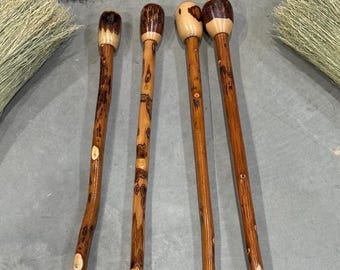 May include: Four wooden walking sticks with natural wood grain and a varnished finish. The tops are rounded and have a lighter wood color. The sticks are brown with lighter wood accents.