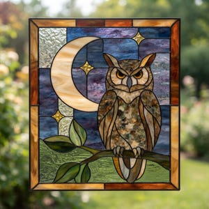 Puede incluir: Un panel de vidriera rectangular que muestra un búho marrón posado en una rama contra un cielo nocturno. La escena incluye una gran luna creciente de color crema y pequeñas estrellas amarillas. El vidrio tiene texturas variadas y tonos azules.
