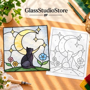 Op de afbeelding: Een glas-in-lood kunstwerk en een bijbehorend genummerd patroonblad met een zwarte kat die op een heuvel zit onder een gele maansikkel en sterren, met roze en blauwe bloemen. De tekst GlassStudioStore is bovenaan zichtbaar.