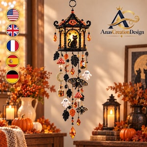May include: A hanging decorative mobile featuring a black lantern structure with a silhouette of a cat inside. It includes dangling charms of white ghosts, red and white mushrooms, moths, crescent moons, small glass bottles, and orange crystals.