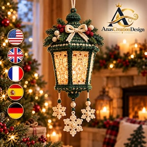 May include: A hanging crochet lantern ornament in dark green and cream, featuring a lace-like pattern, a cream bow, pine needles, and red berries at the top, with three dangling cream-colored crochet snowflakes at the bottom.
