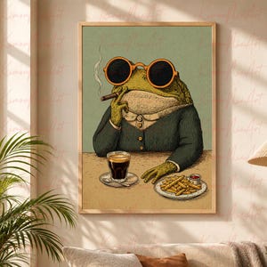 May include: A framed wall art print featuring a green toad wearing a dark green suit jacket and round orange-rimmed sunglasses. The toad holds a cigar, sits at a table with a glass of dark liquid, and has a plate of golden french fries nearby.