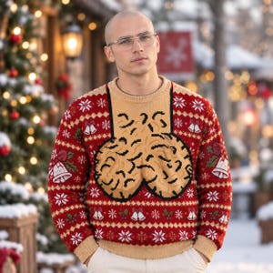 Peut inclure: Un pull à manches longues en tricot rouge et beige avec un motif répétitif de flocons de neige et de cloches blancs. Le centre de la poitrine présente un grand motif graphique beige, souligné de noir, sur un fond rectangulaire beige uni.