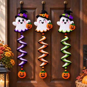 Puede incluir: Tres adornos de pared de fantasmas tejidos a ganchillo, cada uno con un sombrero de bruja y una pequeña calabaza naranja. Debajo de cada fantasma hay una larga cola en espiral multicolor que termina en una calabaza y cuentas de colores.