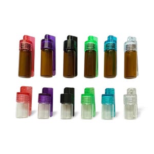 May include: A collection of twelve small glass vials arranged in two rows. The top row features six amber glass vials with colored plastic caps in red, purple, black, green, blue, and clear. The bottom row contains six clear glass vials.