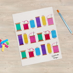 Puede incluir: Una hoja de papel blanca con carretes de hilo de colores y agujas. Los carretes están dispuestos en filas de tres. Los colores del hilo son rosa, amarillo, verde, azul y morado. El texto "Haciendo Vestir" está en la parte inferior de la página.