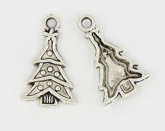 May include: Two silver charm pendants in the shape of a Christmas tree. One tree has a star on top and is decorated with small circles. The other tree is plain.