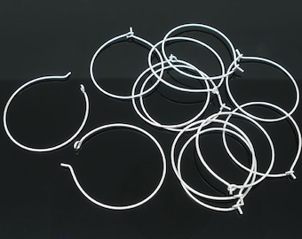 May include: A set of ten silver hoop earrings. The hoops are all the same size and are made of a thin, wire-like material.