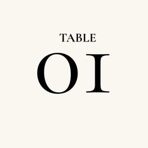Op de afbeelding: Een rechthoekig bruiloftstafelbord met een crèmekleurige achtergrond en zwarte schreefletters. Bovenaan staat EMMA & NOAH 12 SEPTEMBER 2027. In het midden staat TABLE 01 in een groot lettertype. Onderaan staat WELCOME TO OUR WEDDING.