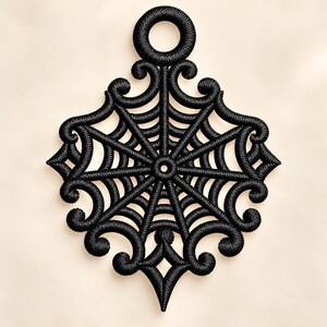 May include: A black embroidered ornament featuring a central spider web pattern surrounded by intricate, symmetrical scrollwork and flourishes. The design includes a circular loop at the top for hanging, all rendered in dense, raised black thread.