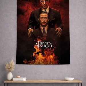 May include: A rectangular wall tapestry featuring the movie poster for The Devil's Advocate. The design displays two men in dark suits against a deep red and black background with flames at the bottom and the white text Devil's Advocate.