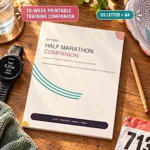Op de afbeelding: Een wit trainingsboek getiteld MY FIRST HALF MARATHON COMPANION met turquoise gebogen lijnen, een donkerpaarse horizontale balk met de tekst PLAN | PRACTICE | TRUST | FINISH en een roze cirkelvormig accent op de omslag.