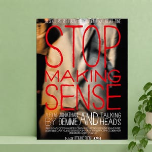 May include: A rectangular movie poster for Stop Making Sense, featuring a blurred figure in a tan suit against a black background. The title is written in large, bold red letters, with white text listing the director, band, and production credits.