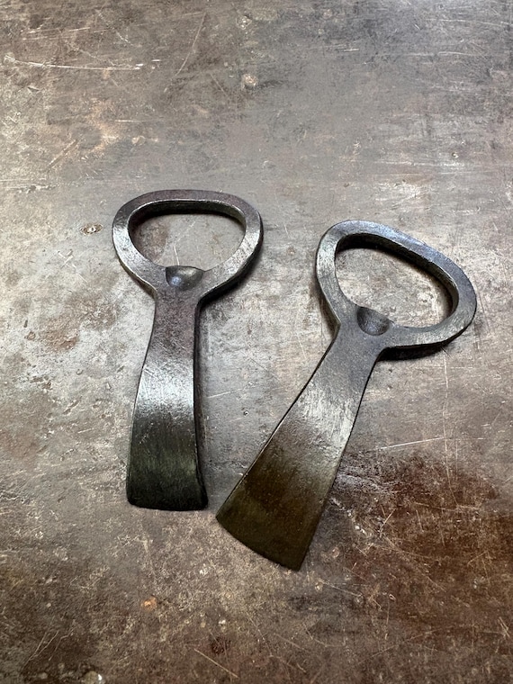 Forged by an actual blacksmith at an actual anvil — a bottle opener with visible hammer marks and a story behind every curve.