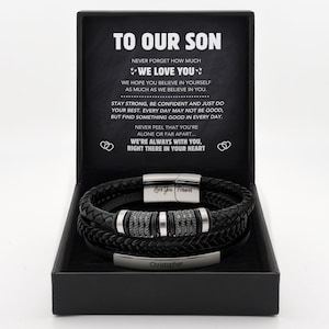 May include: A black braided leather bracelet with silver-tone metal accents and a rectangular plate engraved with the name Christopher, presented in a black gift box featuring the printed message To Our Son and a heartfelt sentiment.