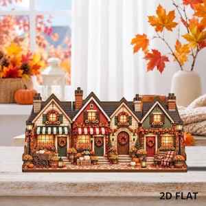 May include: A miniature village display featuring four connected buildings with autumn-themed decor, including orange and red fall foliage, pumpkins, and wreaths on doors and windows. The structure is illuminated with warm lights and labeled 2D FLAT.