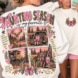 Może przedstawiać: Kremowa bluza z dużym nadrukiem na plecach z napisem "HUNTING SEASON is my favorite". Wzór zawiera cztery panele przedstawiające jelenia, ciężarówkę, ambonę myśliwską oraz sprzęt, ozdobione różowymi kokardami i sercami.