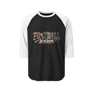 May include: A black and white raglan baseball shirt featuring a graphic on the chest with the text FOOTBALL SEASON. The letters are decorated with various patterns including leopard print, plaid, and stripes, with a football replacing the letter O.