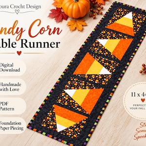 May include: A rectangular table runner featuring a repeating candy corn pattern with large orange, yellow, and white triangles set against a black background with small candy corn motifs. The runner measures 11 by 44 inches and has a colorful border.