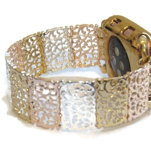 以下が含まれることがあります： 繊細で複雑な花柄のゴールド、シルバー、ローズゴールドのApple Watchバンドです。