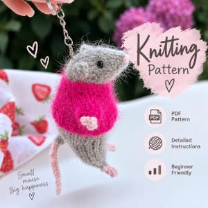 May include: A gray knitted mouse keychain wearing a bright pink sweater, featuring a metal keyring, black bead eyes, and pink paws. The image includes text reading Knitting Pattern, PDF Pattern, Detailed Instructions, Beginner Friendly, and Small mouse Big happiness.