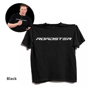 May include: A black short-sleeved t-shirt featuring the word ROADSTER printed in white capital letters across the chest. The shirt is displayed flat, and a circular inset shows a person wearing the same black t-shirt while holding a microphone.