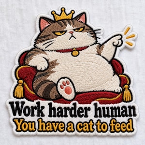 May include: An embroidered patch featuring a grumpy brown and white tabby cat wearing a gold crown, sitting on a red velvet cushion with gold tassels. The text reads: Work harder human You have a cat to feed in black and gold lettering.