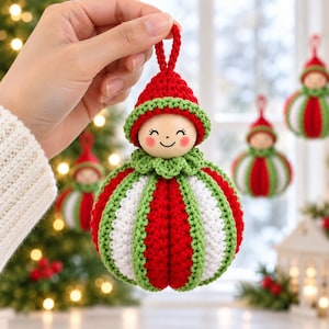 May include: A crochet Christmas ornament featuring a round body with alternating red, white, and green vertical stripes. The ornament has a wooden head with a painted smiling face, rosy cheeks, and a red and green crochet hat with a hanging loop.