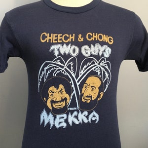May include: A navy blue t-shirt with a graphic of Cheech and Chong, with the text "Cheech & Chong Two Guys From Mekka".