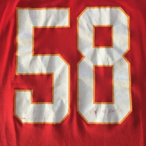 May include: Red jersey with white number 58 outlined in gold.