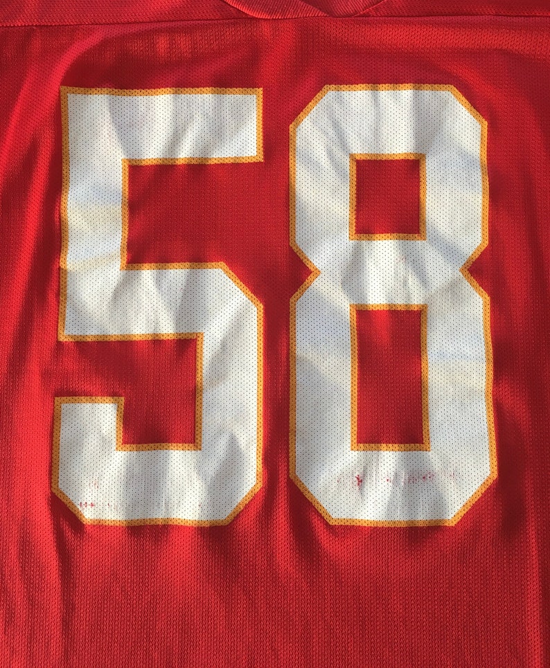 May include: Red jersey with white number 58 outlined in gold.