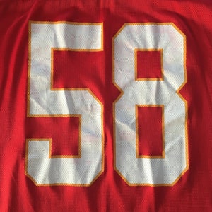 May include: Red jersey with a white number 58 outlined in gold.