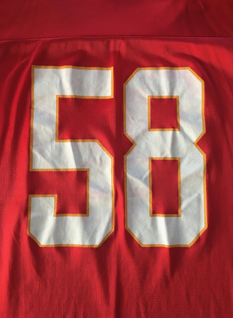 May include: Red jersey with a white number 58 outlined in gold.