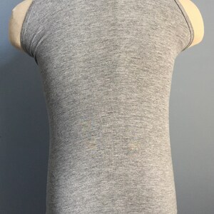 May include: A gray sleeveless tank top with a scoop neck.