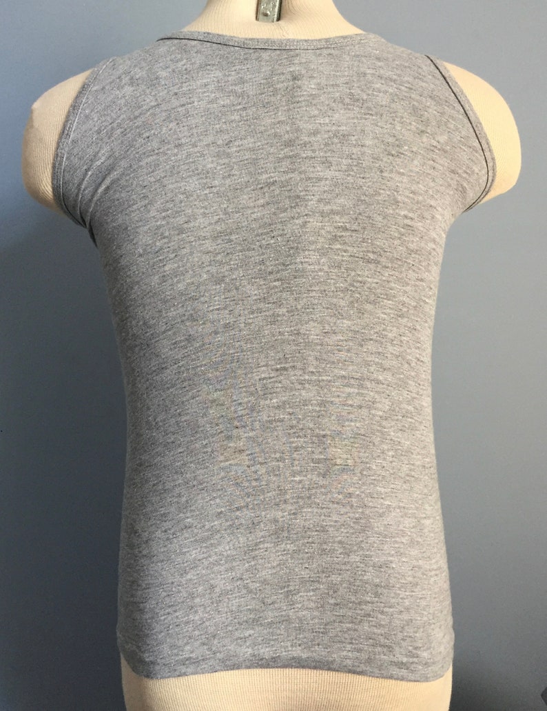 May include: A gray sleeveless tank top with a scoop neck.